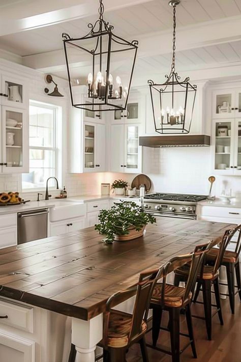 Illuminate Your Dining Area with Farmhouse Kitchen Lighting - Quiet Minimal Large Farmhouse Kitchen Island With Seating, Kitchen For Hosting, White Kitchen With Table, Farmhouse Open Kitchen And Living Room, Table In Middle Of Kitchen, Dining Area Lighting Ideas, Farmhouse Kitchen White Cabinets, Dining Area Lighting, Farmhouse Modern Kitchen