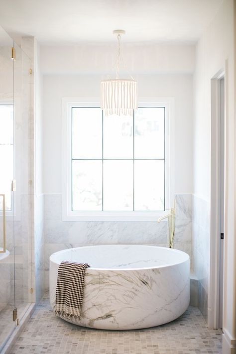 A round marble bathtub in a sparkling white and marble bathroom. Bright, glamorous, simple bathroom design. Bathroom Natural Wood, Cher House, Bathroom Chandelier Lighting, Round Bathtub, Bathroom Natural, Bathroom Chandelier, Marble Bathtub, Marble Tub, Contemporary Bathtubs