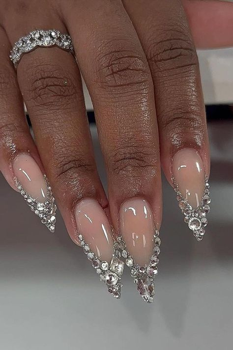 Stiletto nails making a statement with their luxurious crystal embellishments. The nude base provides a classic, understated canvas, allowing the sparkling rhinestones to truly shine, adding a touch of glamour to any look. Stunning and sophisticated! 💎✨  // Photo Credit: Instagram @bcollectivemag Nails 777, 777 Design, Pink Stiletto Nails, Stiletto Shaped Nails, Long Stiletto Nails, Holiday Nail, Pearl Nails, January 3, Diamond Nails