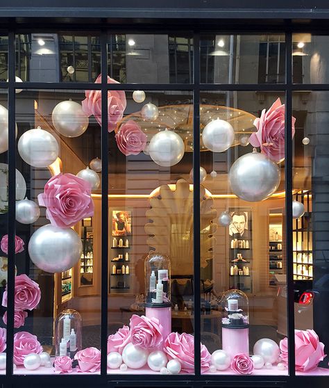 A l’occasion du lancement de son nouveau soin à base de roses et de rassoul, Soline d’Aboville anime la vitrine de la boutique du coiffeur Christophe Robin 16 rue Bachaumont à Paris : La légèreté et le volume s’expriment à travers une installation de bulles nacrées et de roses en papier de différentes tailles dont la composition projette le passant dans un univers doux et poétique. Store Opening Decoration Ideas, Salon Window Display, Christmas Salon, Boutique Window Displays, Valentines Window Display, Window Display Retail, Decoration Vitrine, Christophe Robin, Store Window Displays