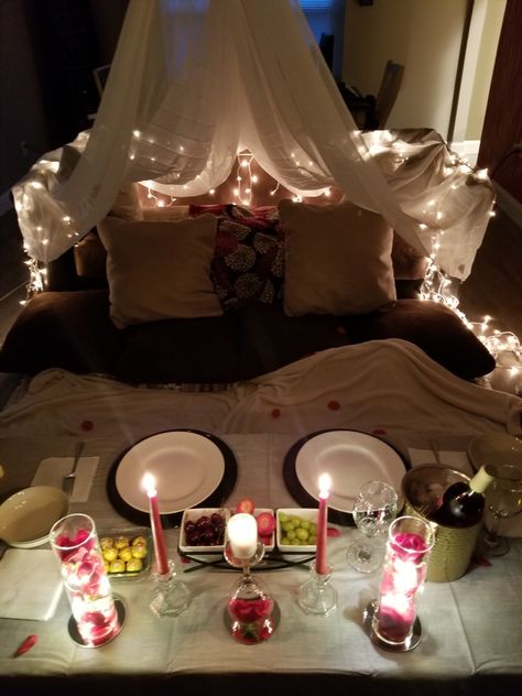 Make your indoor date night romantic!  You can use xmas lights to add to the ambiance along with comfy pillows! To create a fort you can use sheer curtains, they're lighter than sheets! Romantic Night Decor, Patio Date Night Ideas Romantic, Living Room Dinner Date, Vday Date At Home, Indoor Date Setup, Romantic Home Picnic Ideas, At Home Date Night Setup Ideas, Fort Night, Indoor Romantic Date Night