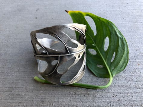 This Monstera Swiss Cheese cuff is hand fabricated with sterling silver sheet and wire. Formed using the heat of my torch, stakes and hammers. It is 2.5" at its widest point and 6" (not including the gap) around.This piece is one of a kind. Sheet Metal Jewelry, Unique Jewelry Inspiration, Jewellery Inspiration, Dope Jewelry, Swiss Cheese, Funky Jewelry, Nature Inspired Jewelry, Jewelry Lookbook, Hammers