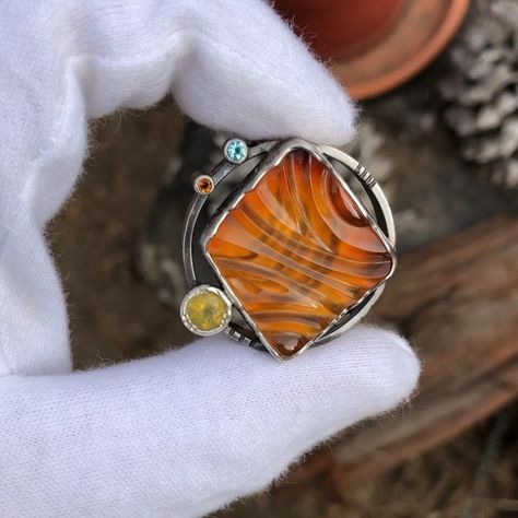 Nicolas TENDAI Cooney on Instagram: “Diggin this electric lil orbital carnelian.. paired with aquamarine, spessartine garnet, and a Nevada opal. Carving done by @fafoutisgems” Spessartine Garnet, Petrified Wood, Nevada, Aquamarine, Garnet, Opal, Gemstone Rings, Jewelry Design, Carving