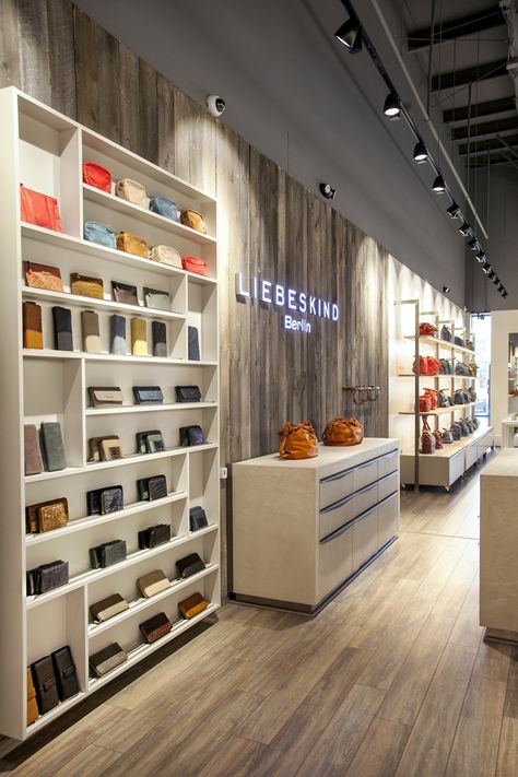 Bag Showroom Display, Retail Power Wall Displays, Contemporary Store Design, Long Narrow Retail Space, Retail Display Fixtures, Bag Store Display Ideas, Shop Flooring Ideas, Store Accent Wall, Bags Store Design