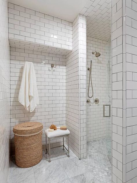 Fabulous bathroom features floor to ceiling walls clad in white subway tiles accented with gray grout lined with a round woven hamper and a Restoration Hardware Newbury Bath Stool under his and hers towel hooks and an overhead shelf. Locker Room Shower, Bathroom Door Hooks, White Tiled Bathroom, Tile Walk In Shower, Tiled Bathroom, Walk In Shower Designs, Tile Remodel, Marble Showers, White Subway Tiles