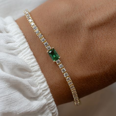 Super chic tennis bracelet with an emerald baguette charm, that is beautiful and elegant! Adds a nice touch of sparkle! Looks like real diamonds! We use a Thick plating of 14k Gold or Rhodium over brass Available in Sizes: 6.5" or 7" 2mm Thickness 4x6mm Baguette Stone Latch Closure Nickel-free, lead free and hypoallergenic Highest Grade CZ for an authentic diamond look Available in Diamond, Sapphire, or Ruby Luxury Baguette Cut Gemstone Bracelets, Luxury Elegant Tennis Bracelet With Emerald, Luxury Green Tennis Bracelet As Gift, Jewellery Wardrobe, Zales Jewelry, Emerald Bracelet, Bridesmaid Gifts Jewelry, Chunky Earrings, Jewelry Design Inspiration