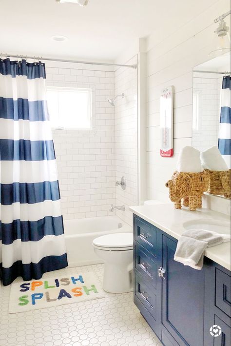 This blue and white bathroom was perfect for my son! We dressed up the space with a cute Splish Splash rug, woven elephant towel holder, and navy vanity! To see more paint colors used in the home, head to the blog! Makeover Kamar Mandi, Farmhouse Bathrooms, Kids Bath Mat, Kid Bathroom Decor, Boy Bath, Bubble Baths, Guest Bathrooms, Boys Bathroom, Apartment Bathroom