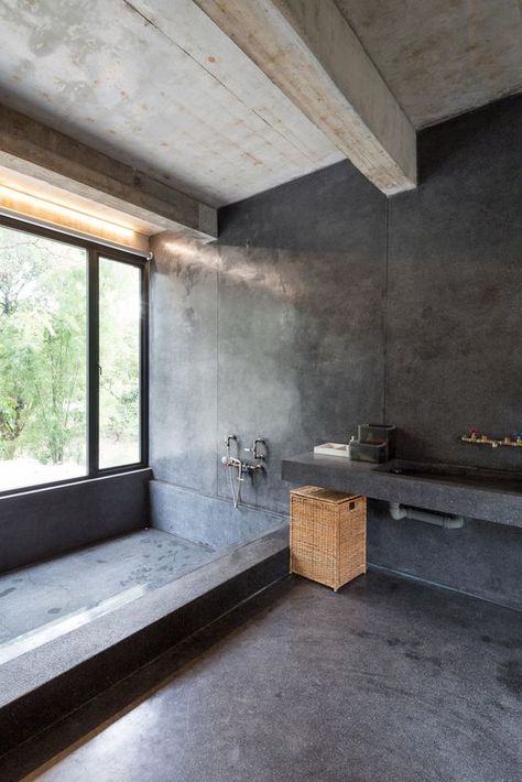 a minimalist industrial bathroom done with white concrete and black stone, a large built in tub, a vanity with a built in sink and a basket Luxury Bathroom Must Haves, Industrial Bathroom Design, Sunken Tub, Grey Bathrooms Designs, Japanese Bathroom, Concrete Bathroom, Concrete Houses, Concrete Walls, Wooden Bath