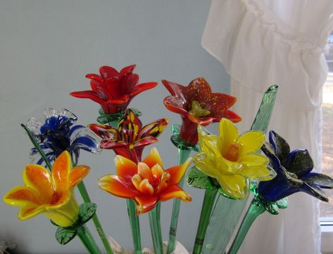 An assortment of our most popular glass flowers. They are all sold individually in price ranges from $9.99 to $14.99 Blown Glass Flowers, Glass Flower Bouquet, Soft Solder, Big Painting, Glass Bottles Art, Glass Pumpkins, Flower Display, Glass Flowers, Delicate Flower