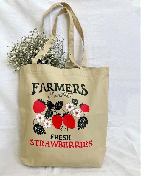 Canvas tote bag with the words farmers market fresh strawberries along with illustrated red strawberries and white flowers Strawberry Vibes, Strawberry Tote Bag, Physical Manifestation, Farmers Market Tote Bag, Strawberry Bag, October Vibes, Colorful Floral Art, Rain Aesthetic, Vegetable Bag