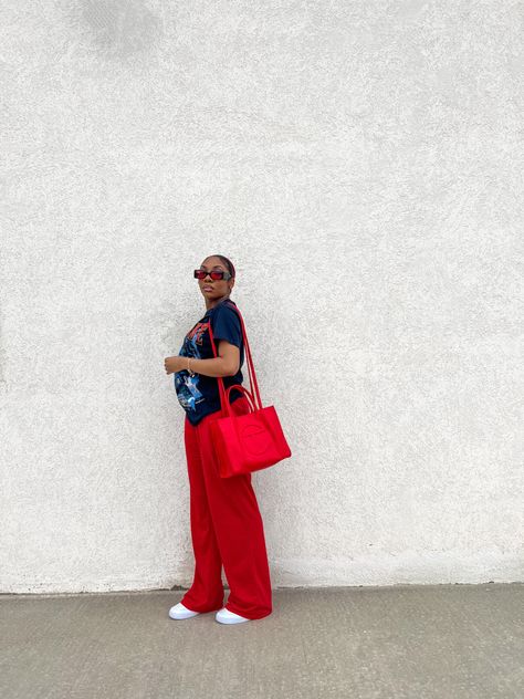 black girl in ice cube red and blue graphic tee, red sweatpants, air force 1s, red telfar bag Outfit With Air Force, Outfit With Air Force 1, Red Telfar Bag, Outfits With Air Forces, Streetwear Outfit Black, Girl Casual Outfits, Girl Streetwear Outfit, Black Woman Outfits, Graphic Tee Outfit