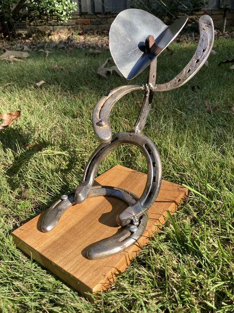 Horseshoe cowboy that resembles a bull rider! Each horseshoe is used and they come from various horses across West Alabama! Made with upcycled materials which would have otherwise been discarded

#horseshoecowboy #horseshoe #horses #horsedecor #horseshoedecor #horselover #cowboyart #cowboyhome #upcycled #homedecor #rusticdecor #tabletopart #bullriderart #bullriderdisplay #bullrider #broncrider #rodeoart Horseshoe Metal Art, Horseshoe Welding Projects, Horseshoe Cowboy, Horse Shoe Cowboys, Horse Shoe Welding, Horseshoe Art Welded Sculptures & Statues, Horseshoe Decor, Bull Riders, Horseshoe Art