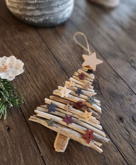 Rustic Christmas tree ornament made from driftwood and popsicle stick with wood star embellishments and twine around the tree stump Christmas Stick Crafts, Recycled Tree Craft, Driftwood Xmas Tree, Dowel Christmas Tree Diy, Christmas Tree With Sticks, Driftwood Christmas Trees, Nature Christmas Tree Decorations, Driftwood Christmas Crafts, Driftwood Ornaments Diy