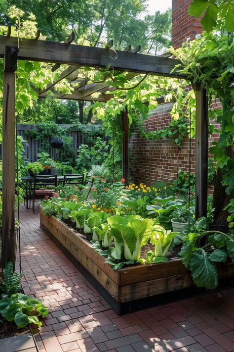 A lush garden featuring raised beds with leafy greens and flowers under a wooden pergola, with a patio dining area in the background. Backyard Vegetable Garden Ideas, Edible Front Yard, Backyard Vegetable Garden, Gardening Food, Edible Landscape, Small Vegetable Gardens, Chicken Garden, Backyard Vegetable Gardens, Edible Landscaping