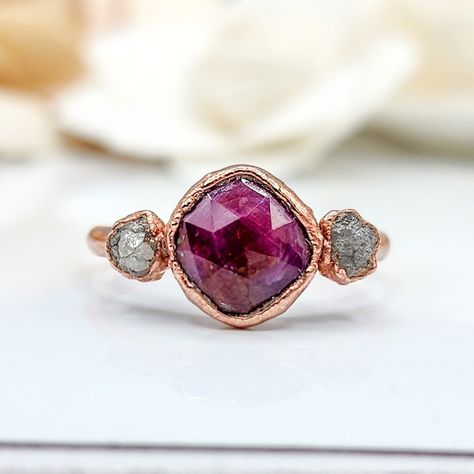 ♡ Ruby and Rough Diamond Ring This earthy ring featuring a vibrant polished ruby set alongside a raw diamond, all elegantly encased in warm rose gold. The juxtaposition of the deep red ruby with the natural, uncut diamonds creates a striking contrast that highlights the unique beauty of each stone. #ruby #rubyring #rawdiamdondring #uncutdiamondring #uniqueengagementring #alternativeengagementring #bohorings #gemstonering #hippiestyle Engagement Ring Boho, Earthy Rings, Raw Stone Engagement Rings, Birthstone Jewelry Mothers, Uncut Diamond Ring, Raw Diamond Ring, Handmade Engagement Ring, Diamond Ring Unique, Ruby Set