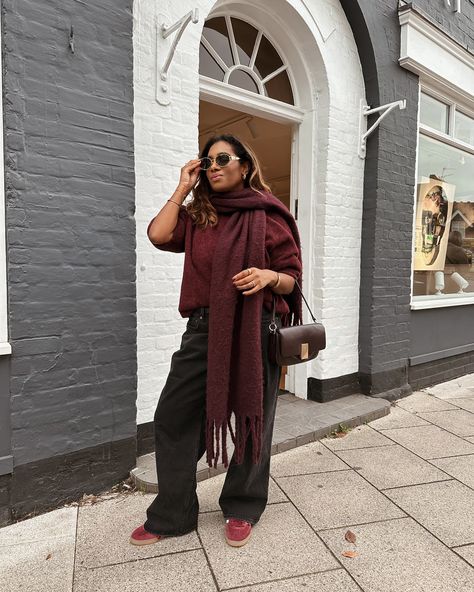 Woman wearing a cozy burgundy oversized sweater and scarf paired with black trousers and burgundy trainers, standing outside a stylish building. Perfect autumn street style outfit for petite styling. Petite Styling, Burgundy Aesthetic, Adidas Bag, Outfits For Petite, Petite Bloggers, Sunglasses Celine, Trainers Adidas, Burgundy Outfit, Adidas Bags