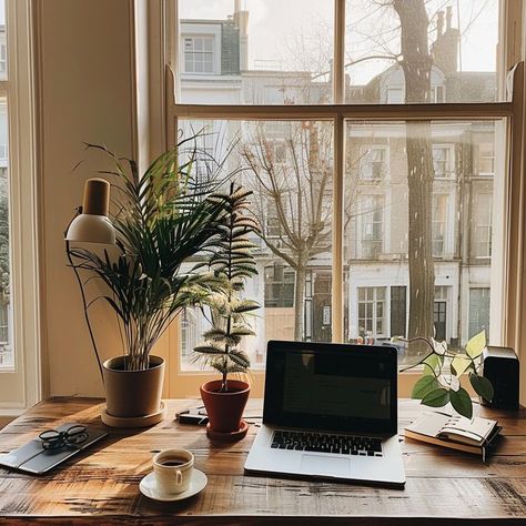 Serene home workspace with natural light, wooden desk, laptop, coffee cup, books, stationery, and indoor plants for productivity and tranquility. Surrounded By Books, Serene Home, Home Workspace, Morning Vibes, Steaming Cup, Calming Atmosphere, Modern Home Office, Wooden Desk, Day Work