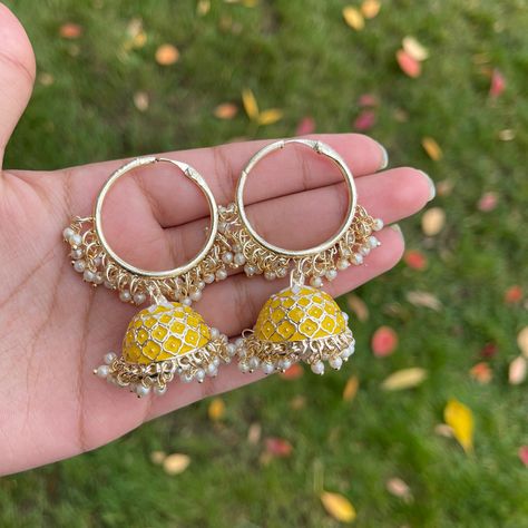 Liven up your outfit with our lovely Yellow Mishti jhumka Bali earrings. These gold-plated jhumkas have hand-painted meenakari with dangling pearls. Specifications Materials used: meenakari, pearls, gold plating Length: 6 cm Weight: 35 grams At Romikas, we pride ourselves on the craftsmanship and high quality of our jewelry, designed to enhance your natural beauty. Please contact us with any questions. Jhumka Design, Indian Bridal Jewelry Sets, Bali Earrings, Desi Aesthetic, Yellow Jewelry, Jhumki Earrings, Indian Jewelry Sets, Bangles Jewelry Designs, Dress Indian