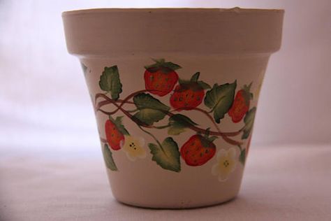 Hand painted clay flower pot with strawberry vine on a cream background. This would make a nice gift for a garden lover or a hostess gift or a gift for yourself for patio, porch or garden decor. Add a battery operated tea light or sand and a candle for an outdoor patio light. Clay pot is Paint Garden Pots, Strawberry Vine, Strawberry Pot, Strawberry Pots, Terra Cotta Pot Crafts, Painted Pots Diy, Flower Pot Design, Painted Plant Pots, Terracotta Flower Pots