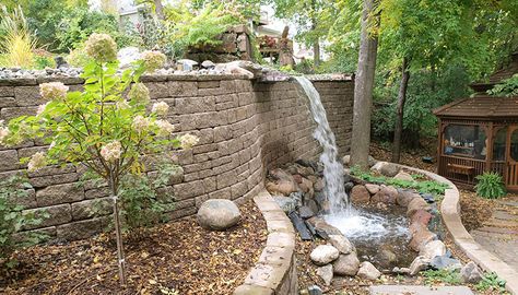 Waterfall Retaining Wall, Back Yard Up Hill, Yard Slopes Toward House, Leveling Yard Sloped Backyard, Back Yard On A Hill Sloped Yard Retaining Walls, Landscape Design On Sloping Terrain, Playground Landscaping, Landscaping A Slope, Landscaping On A Hill