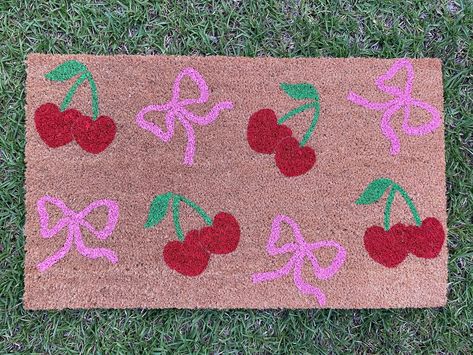 Cherry and Bow Doormat Our doormats make great gifts for holidays, housewarmings, anniversaries, birthdays, weddings, or just because! Our doormats are made of 100% natural coir and have a slip-resistant vinyl backing. All doormats are hand-painted with weather-resistant paint and sealed with a UV protectant spray. All of our doormat designs can be personalized! Want to change the color or add your name? Send us a message on Etsy or a DM us on Instagram to get started! Our Instagram account is @ Doormat Diy Ideas, Painted Front Door Mat, Rug Painting, Paint A Doormat, Door Mat Painting Diy, Doormat Painting Ideas, Painted Doormat, Doormat Ideas Funny, Diy Doormat Paint