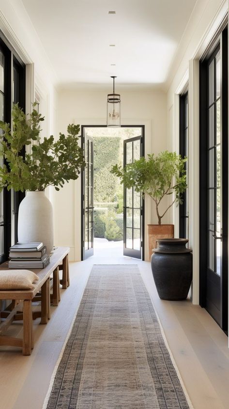 A beautifully well proportioned hallway with lovely black French doors, a gorgeous rug and fabulous styling Modern Building Entrance Design, Timeless Home Interior Design, Internal House Design, Modern European House Interior Design, Ceiling Design Farmhouse, Floor To Ceiling Art, European Style Home Decor, Transitional Home Interior Design, Modern Timeless Interior Design