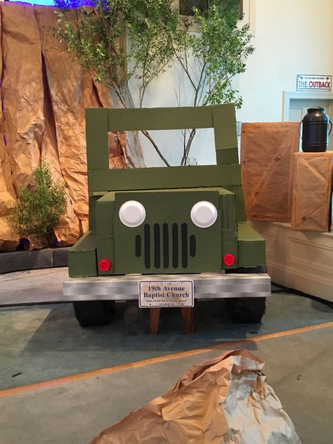 Cardboard Jeep. I'm a little bummed that the windshield bent in transport but it still turned out pretty nice. Bumper covered with "metal" ducttape from Dollar General. Foam plate headlight, bottom of Solo cup runner lights (I guess that's what they're called). Cardboard Jeep Photo Prop, Cardboard Jeep Diy, Safari Jeep Cardboard Diy, Jeep Photo Booth, Diy Safari Decorations, Cardboard Jeep, Zoomerang Vbs, Vbs Decorations, Safari Jeep