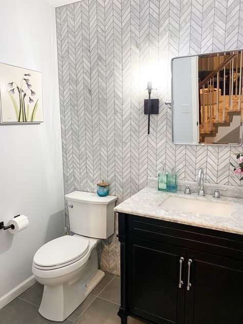 Another design project in the books! This powder room was transformed into a gorgeous modern oasis with a chevron tile backsplash/ accent wall, simple black vanity, marble counter top, and mixed metals of chrome and matte black finishes 🙌🏼.  #liketkit #LTKhome #LTKfamily @liketoknow.it @liketoknow.it.home http://liketk.it/2KQak Tiled Walls In Powder Room, Powder Room Ideas With Tile Wall, Power Room Tile Wall, Powder Bathroom Tile Wall, Half Bathroom Ideas Wallpaper Modern, Tiled Wall Powder Room, Tile Wall In Powder Room, Powder Room Tile Accent Wall, Powder Room Half Wall Tile