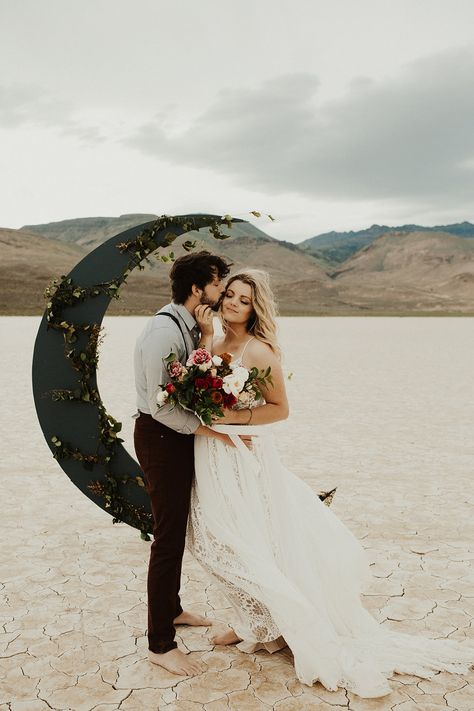 lunar moon backdrop for windy desert elopement. Groom wearing light blue and suspenders, bride in flow gown with dark red bouquet Celestial Wedding Theme, Starry Night Wedding, Bridal Atelier, Bohemian Wedding Inspiration, Moon Wedding, Wedding Altars, Celestial Wedding, Boho Wedding Inspiration, Desert Wedding