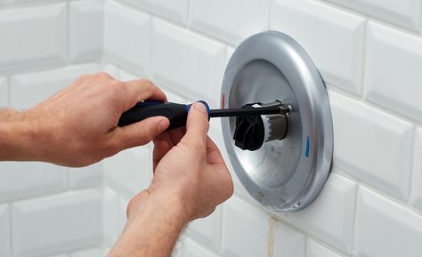 A person unscrews the cover of a bathtub faucet handle. Replace Tub Faucet, Replace Bathtub Faucet, Shower Plumbing Fixtures, Replace Bathroom Faucet, Remove Bathtub, Bathtub Repair, Bathtub Spouts, Bathtub Spout, Shower Plumbing