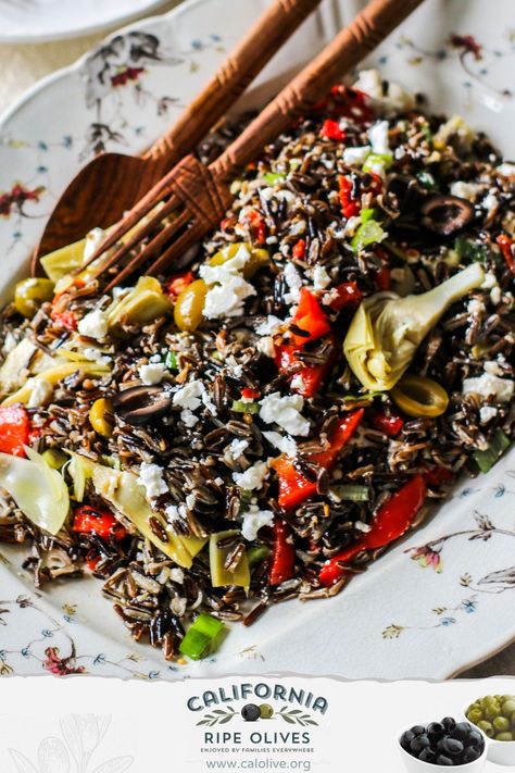 This Mediterranean Wild Rice Salad is perfect for busy families! Because it's best served cool or at room temperature, simply make it ahead of time and pull it out when you're ready for dinner. Roasted bell peppers, artichoke hearts, sun dried tomatoes, green and black olives and feta cheese make for a flavorful (and healthy) meal!  You might want to make a little extra - leftovers are even better the next day for lunch. #calripeolives #wildrice #salad #makeahead Wild Rice Artichoke Salad, Gf Salads, Marinated Artichokes, Roasted Bell Peppers, Artichoke Salad, Wild Rice Salad, Olive Salad, Olive Recipes, Holiday Eating