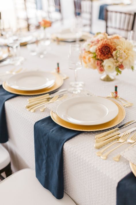 Guests sat along long tables set with white linens embroidered with a Swiss dot design and topped with navy napkins. Gold chargers and silverware brought an added elegance to the tablescapes. Jamie loves a bit of spice, so mini bottles of Tabasco sauce were placed at each place setting. Napkins Wedding Table, Gold Chargers, Wedding Table Linens, Blue Napkins, Wedding Place Settings, Table Set Up, Navy Wedding, Nautical Wedding, Wedding Table Settings