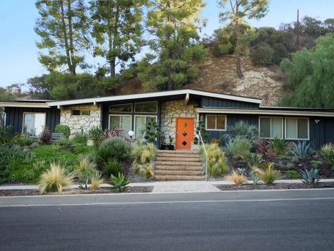 Location: Woodland Hills, CA Built in: 1959 Size: 2,227 sq. ft. Paint colors: Raccoon Fur (house), Benjamin Moore; Japanese Koi (door), Behr Homeowners Shida and Leandro Amaral opted not to make many changes to the exterior of their ranch home, built by famous architect Charles Du Bois. A new, custom door (which mimics a popular 1950s design) and fresh paint were the only updates they made to the façade. They also chose to plant pampas grass, cacti, lavender and other plants inspired by the desert landscapes of Palm Springs. "The grown children of the previous owners still live in the neighborhood," say Shida and Leandro, "and they said the work we’ve done on the house is amazing!" Palm Springs Style Home Exterior, Updated Midcentury Modern Exterior, Update Mid Century Home Exterior, 50s House Exterior Paint Colors, Ranch House Facade, Mid Century Ranch House Exterior, Rancher Exterior Paint Colors, Mid Century Brick House, Tan Ranch House Exterior Color Schemes