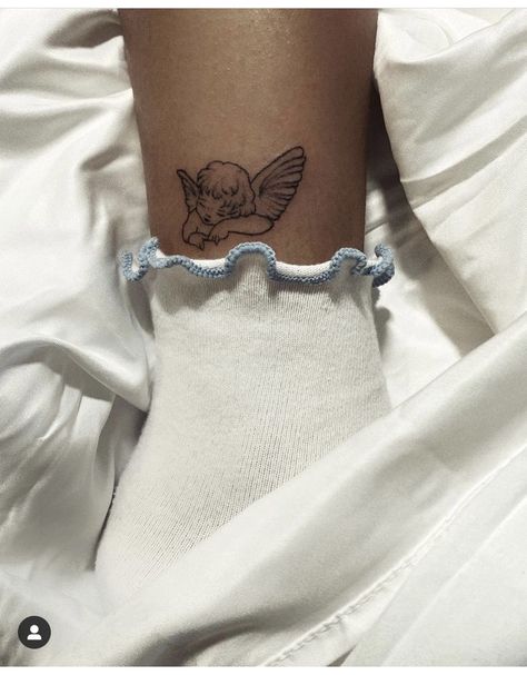 Cherub Flower Tattoo, Ankle Angel Tattoo, Cherub Tattoo Minimalist, Angel Tattoo Placement Ideas, Cherub Ankle Tattoo, Cherub Kissing Tattoo, Small Cherub Tattoo Simple, Minimalist Cherub Tattoo, Cherub Tattoo Back Of Arm