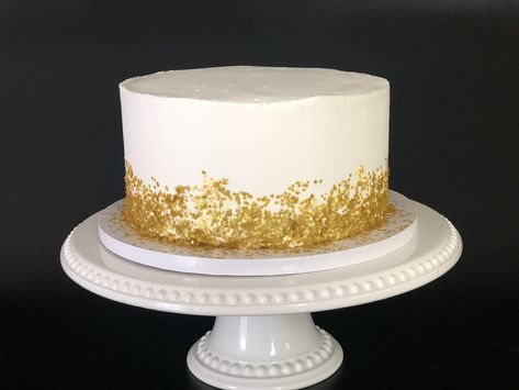 Watch this video to see how you too can make this elelgant white and gold cake! White Cake Gold Flakes, White Cake Gold Sprinkles, Gold Fleck Cake, Simple Wedding Cake White And Gold, White And Gold Birthday Cake For Men, White And Gold 40th Birthday Cake, Gold White Cake Birthday, White Cake With Gold Accents, White And Gold Smash Cake