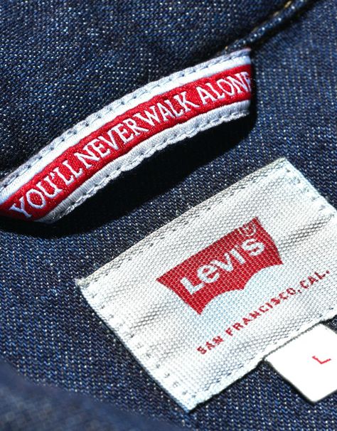 Football clubs have all sorts of official partners these days. ‘Health Insurance’, ‘Skincare’ and ‘Gaming’ Providers are all genuine partners with Premier League teams. But there’s probably no more random official partner than Liverpool FC’s official ‘Denim Partner’. That said, it is Levi’s. And the first ever Levi’s x LFC capsule collection does provide some standout pieces. Denim Label, Shirt Label, Hang Tags Clothing, Levis Shirt, Fabric Labels, Shirt Refashion, Best Mens Fashion, Denim Branding, Men Shirt Style