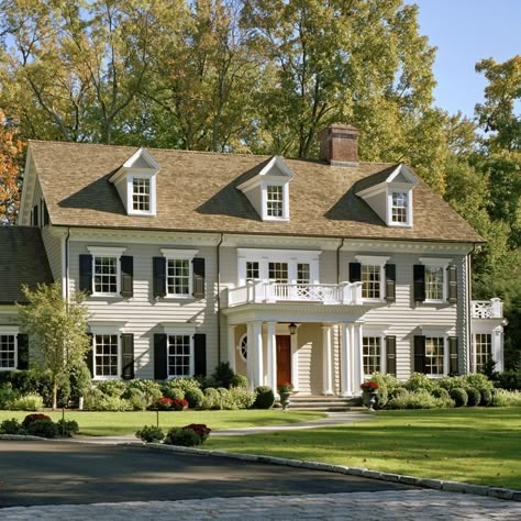 The renovation of this Colonial-style home included raising the roof, adding dormers, and rearranging windows with new casings, sills and head cornices both balance and enliven the façade. Contact us at 203.489.3800 to learn more! #woodhouse #blackshutters #cedarroof #dormers #frontentry #frontyard #colonialrevivalstyle #traditionalarchitecture #classicaldesign #GreenwichCT Colonial Home Exteriors, Georgian Colonial House, Colonial Renovation, Georgian Colonial, Colonial House Exteriors, Colonial House Plans, Porch Addition, Colonial Exterior, Colonial Style Homes