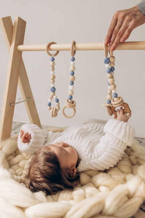 Designed with a Montessori-inspired approach, baby play gym with hanging toys are an excellent first toy for your baby! With its cute toys and neutral colors, this set will blending with any decor. Modern, minimalist, stylish and unique newborn toy. Gender neutral and natural. A must-have for babies and a perfect gift idea for for any occasion: birthday, christening, a baby shower and more. See you in our Etsy shop! ♡ Baby Hanging Toys, Wooden Play Gym, Wooden Baby Gym, Baby Gym Toys, Baby Play Gym, Baby Sensory Toys, Nursery Decor Neutral, Newborn Toys, Play Gym