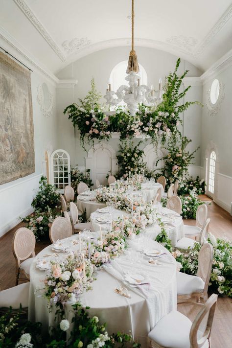 A unique wedding breakfast set up within the large, spacious and light setting of a grand manor house. Serpentine tables snake the room, overflowing with masses of elegant flowers whilst the balcony above bursts with a magnificently striking floral installation. Knotted Napkin, Wedding Tablescapes Round, Wedding Breakfast Decor, Southern Wedding Invitations, Decadent Wedding, Weddings Decorations Elegant Romantic, Carpenter Photography, Bridgerton Wedding, Fairytale Decor