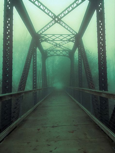 Bridge with metal supports over river with dark green mist around with leaves fallen from trees. Dark trail with bridge Creepy Fog, Foggy Bridge, Abandoned Bridge, Bridge Aesthetic, Fallen Angel Aesthetic, Scary Bridges, Escape The Night, Dark City, Angel Aesthetic