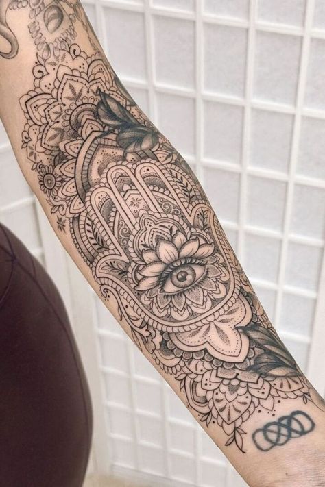 "These 12 beautiful tattoo ideas are perfect for women who want to express their individuality with unique, meaningful ink that stands the test of time." Hamza Hand Tattoo Design, Hamsa Hand Tattoo For Women, Buddhist Tattoo Sleeve, Henna Arm Tattoo, Hamsa Tattoos, Fatima Hand Tattoo, Tattoo Ideas For Woman, Henna Sleeve, Hamsa Tattoo Design