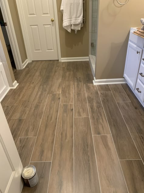 AHmazing pecan wood look tile and tan grout for the master bathroom floor.  We changed the grout to match the tile and like it a lot better Wood Grain Tile Bathroom Floor, Brown Floor Tiles Bathroom, Bathroom With Brown Floor, Brown Floor Bathroom, Wood Looking Tile Floors, Tan Tile Bathroom Ideas, Farmhouse Tile Floor, Bathroom Wood Floor, Wood Bathroom Floor