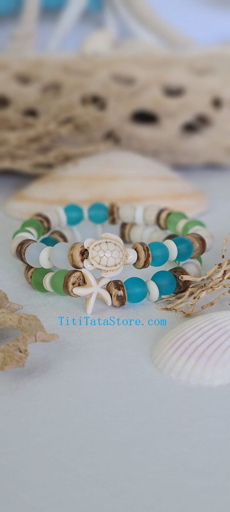 TitiTataStore.com Always FREE SHIPPING and a FREE GIFT! I Will Ship Within 24 Hours! Description: A set of 2 colorful beachy handmade bracelets that will make a beautiful and colorful gift. The perfect gift for a beach lover! Materials:  8mm Frosted Sea Glass beads in White, Blue, and Green, 8mm Wood Beads, 8mm Coconut Shells, White Shell Heishi beads, 6mm Rondelle Bone Beads, 6mm Howlite Beads, and a lovely Howlite Sea Turtle and a Starfish spacer charms. A high-quality elastic stretch cord is used to string the beads together.  Size: Each bracelet is suitable for a wrist circumference of about 7". Final Touch: Your bracelet will be nicely packed in a Burlap Gift Bag. ❤ All orders are shipped FREE via USPS First Class Mail with tracking number. ❤ If you would like a different size, just s Coconut Bead Bracelet, Bracelets Beachy, Bracelets Summer, Beachy Bracelets, Burlap Gift Bags, Coconut Shells, Diy Beaded Rings, Sea Turtle Bracelet, Sea Glass Beads