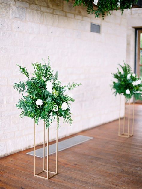 Tall and simple ceremony floral arrangements, made with classic greenery and white roses, that can be moved and used as decor in the reception space | For more information on The Wildflower Center along with many other stunning venues, visit myweddingscout.com | Photographer: Lucy Struve |Venue: Wildflower Center #ceremeonyflorals #weddingflowers #reuseableweddingflorals #weddingflorals #tallweddingflowerarrangement Ceremony Floral Arrangements, Wedding Venues In Texas, Altar Arrangements, Altar Arrangement, Large Floral Arrangements, Greenery Arrangements, Wedding Floral Centerpieces, Wedding Venues Texas, Luxury Wedding Venues