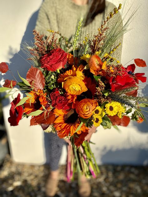 Dyed sunflower, red roses, red poppy, dahlias and fall leaves make the perfect free form fall bridal bouquet. Red Sunflower Bouquet, Dark Sunflower Bouquet, Wild Flower Fall Bouquet, Red Poppy Bouquet, Stardew Wedding, Dahlia Bouquet Fall, Red Sunflower Wedding, Dark Red Wedding, Sunflower Floral Arrangements