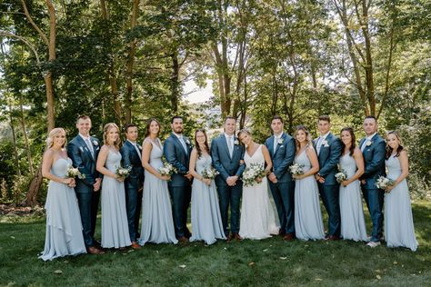 Bridesmaids in long dusty blue dresses and groomsmen in navy suits for coastal Maine wedding party Light Blue Bridesmaid Dresses With Navy Suits, Light Blue Bridesmaid Tan Groomsmen, Dusty Blue Bridal Party Groomsmen, Seaglass Bridesmaid Dresses With Groomsmen, Coastal Groomsmen Attire, Dusty Blue Bridesmaid Dresses Navy Suits, Pale Blue Bridesmaid Dresses With Groomsmen, Light Blue Bridesmaid Dresses Navy Suits, Sky Blue Bridal Party