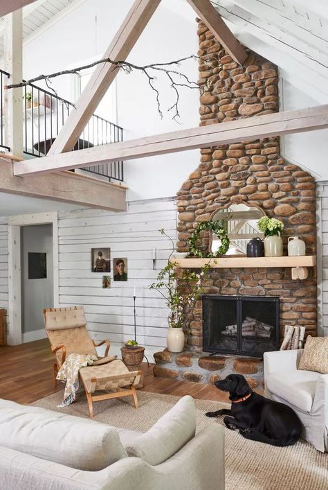 Accent a stunning river rock fireplace with rustic shiplap. To give the shiplap patina, paint it with a few shades of off-white before lightly sanding. The shiplap brightens the space while keeping with the room's aesthetic. #livingroom #shiplap #bhg Shiplap Fireplace Wall, Shiplap Fireplace Ideas, River Rock Fireplace, Rustic Shiplap, River Rock Fireplaces, Grey Fireplace, Rock Fireplace, Installing Shiplap, Patina Paint