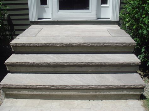 Concrete steps overplayed with brown stone treads Front Steps Stone, Paver Stairs, Front Porch Stone Steps, Backyard Steps, Lake House Patio, Concrete Front Steps, Front Porch Stone, Entry Steps, Concrete Backyard