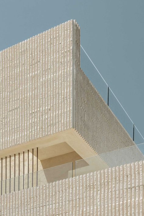 A modern multi-storey home in Menorca, Spain, that features a textured facade of fluted concrete walls. Travertine Steps, Fluted Concrete, White Concrete Floors, Curved Patio, Sunken Patio, Menorca Spain, Facade Material, Building Aesthetic, Concrete Facade