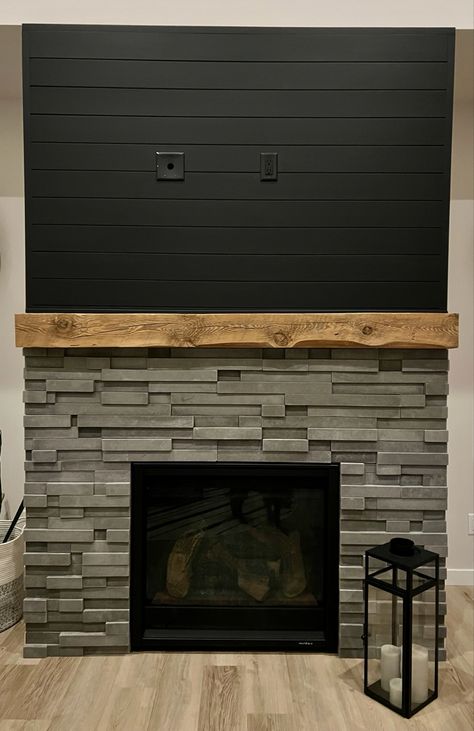 Gray Fireplace Wood Mantle, Black Stone And Shiplap Fireplace, Stone Fireplace With Black Shiplap, White Stone Fireplace Black Wall, Black Shiplap Fireplace With Stone, Black Shiplap Behind Tv, Stone And Black Shiplap Fireplace, Black Shiplap Above Fireplace, Black And Stone Fireplace